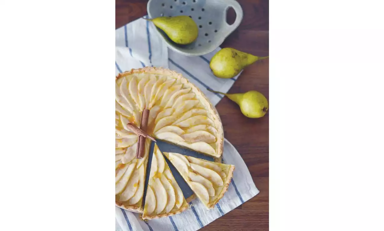 Hruškový tart so zlatistým, mandľovým základom, ozdobený tenkými plátkami šťavnatých hrušiek usporiadaných do súmerných kruhov